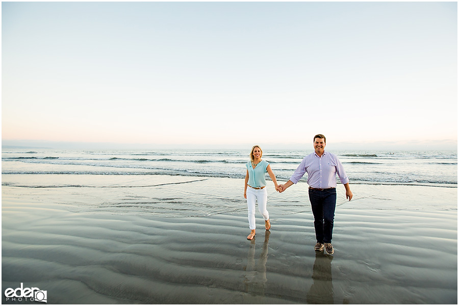 Couple walking on beach during engagement session in Coronado, CA.