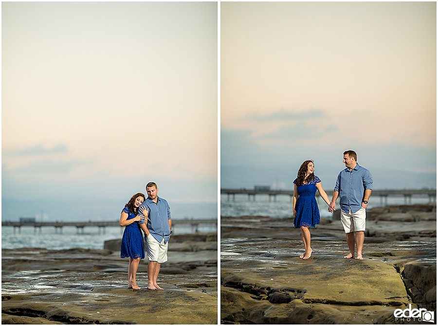 Standing on rocks San Diego Sunset Cliffs engagement session.