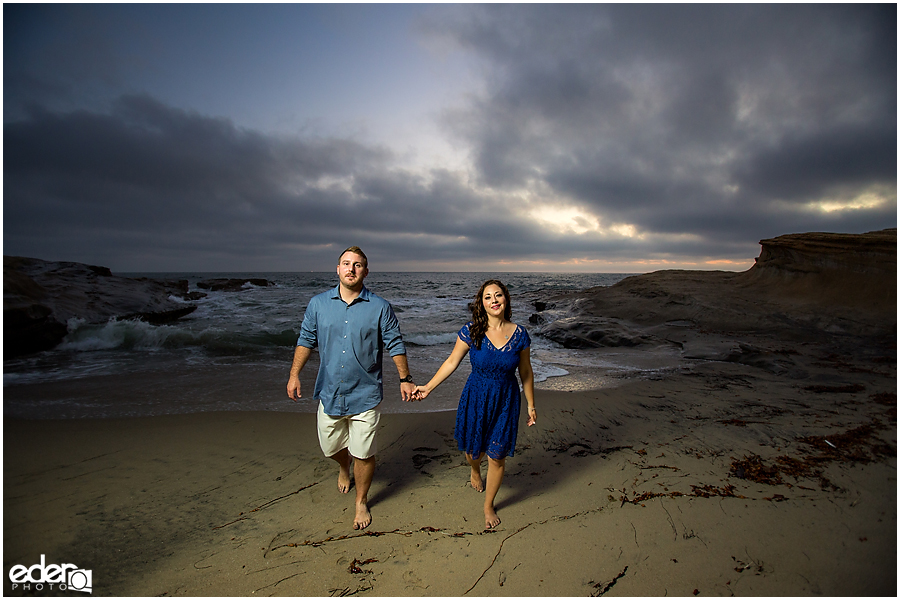 Walking on the sand during San Diego Sunset Cliffs engagement session.