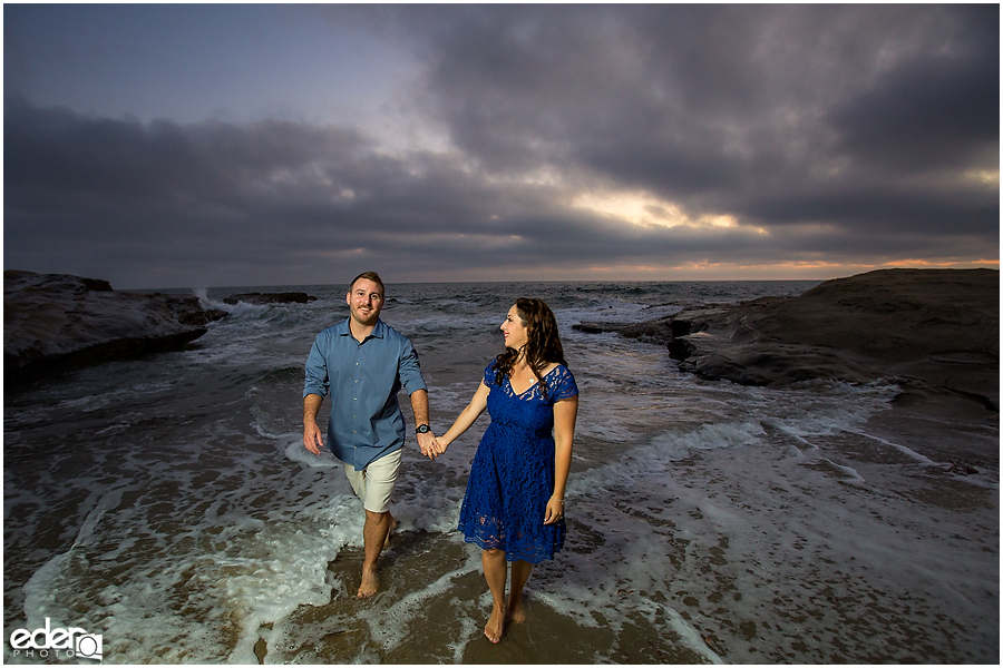 Walking in water during San Diego Sunset Cliffs engagement session.