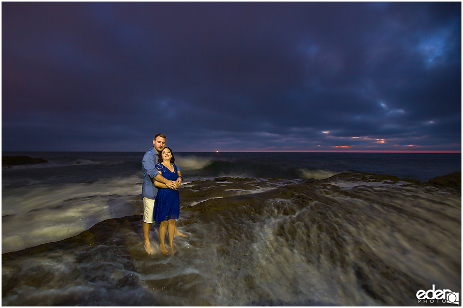 Standing still as water rushes by during an engagement session.