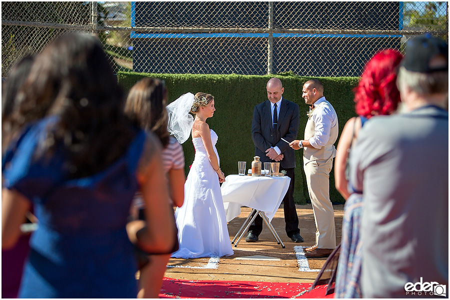 Exchanging vows during baseball themed wedding ceremony. 