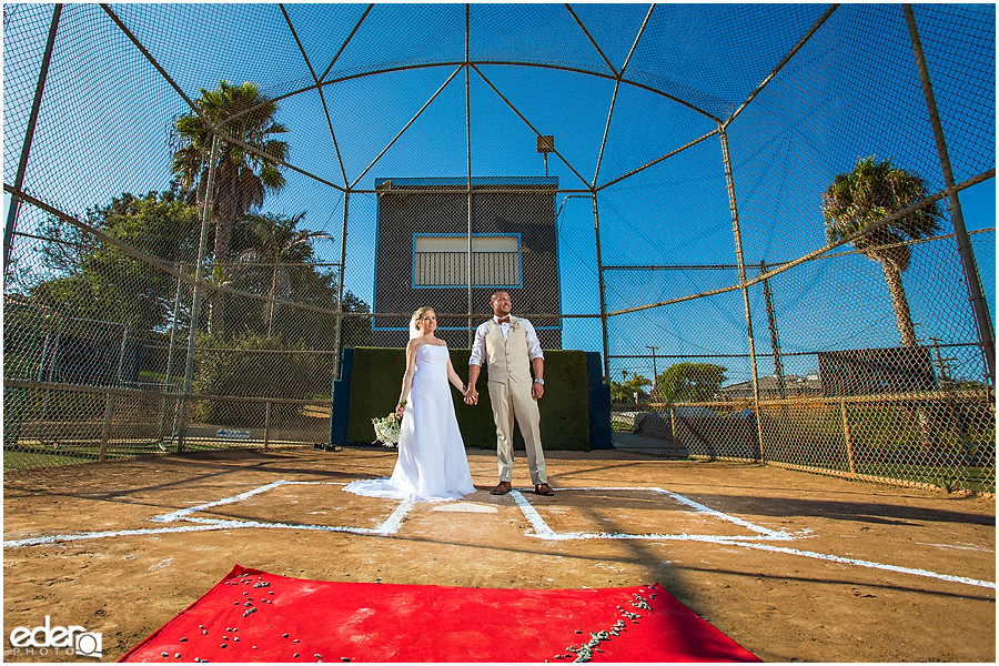 Bride and groom at home plate after baseball themed wedding ceremony. 